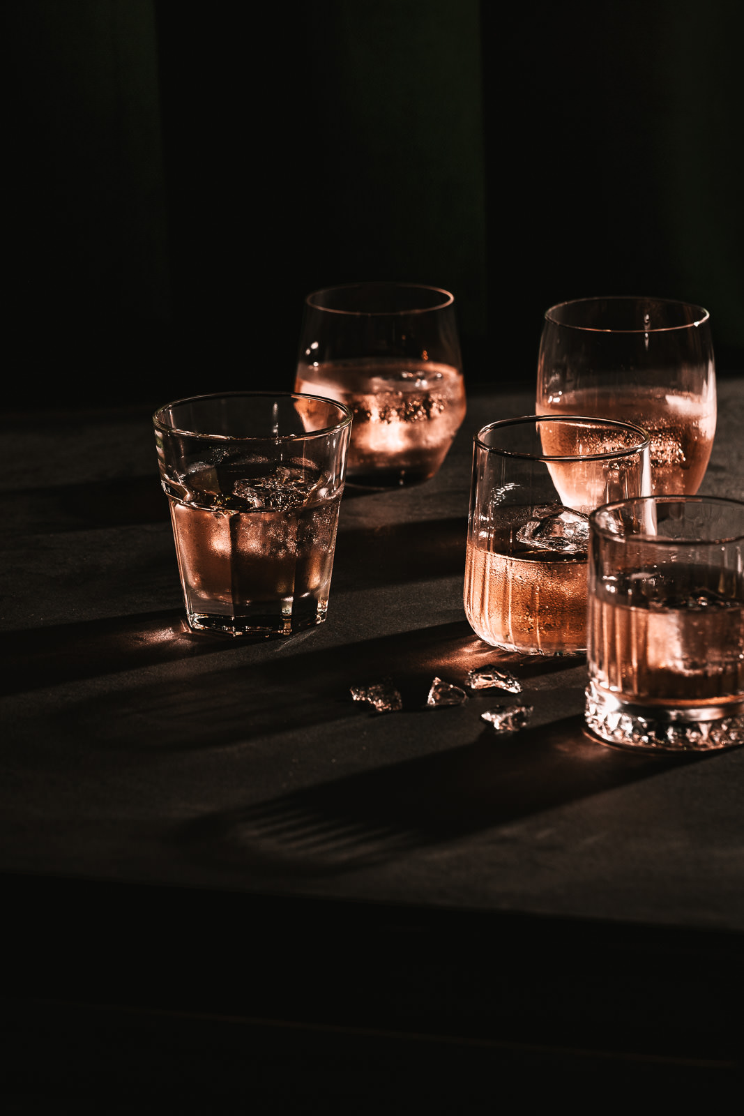 Verschiedene Gläser gefüllt mit Saft in einer Abendstimmung fotografiert